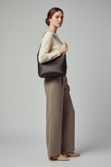 Female model carrying Modern Everyday Shoulder Bag in Black Coffee